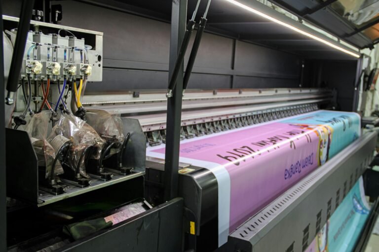 Grootformaatprinter met een bedrukte banier op de rol